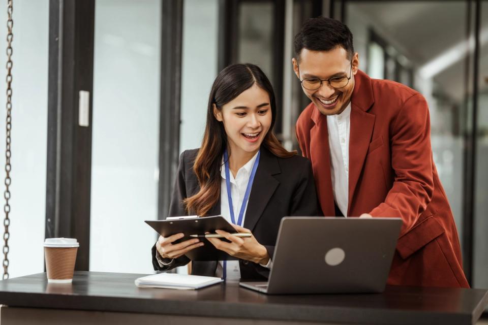 Man and woman in office setting looking at computer screen