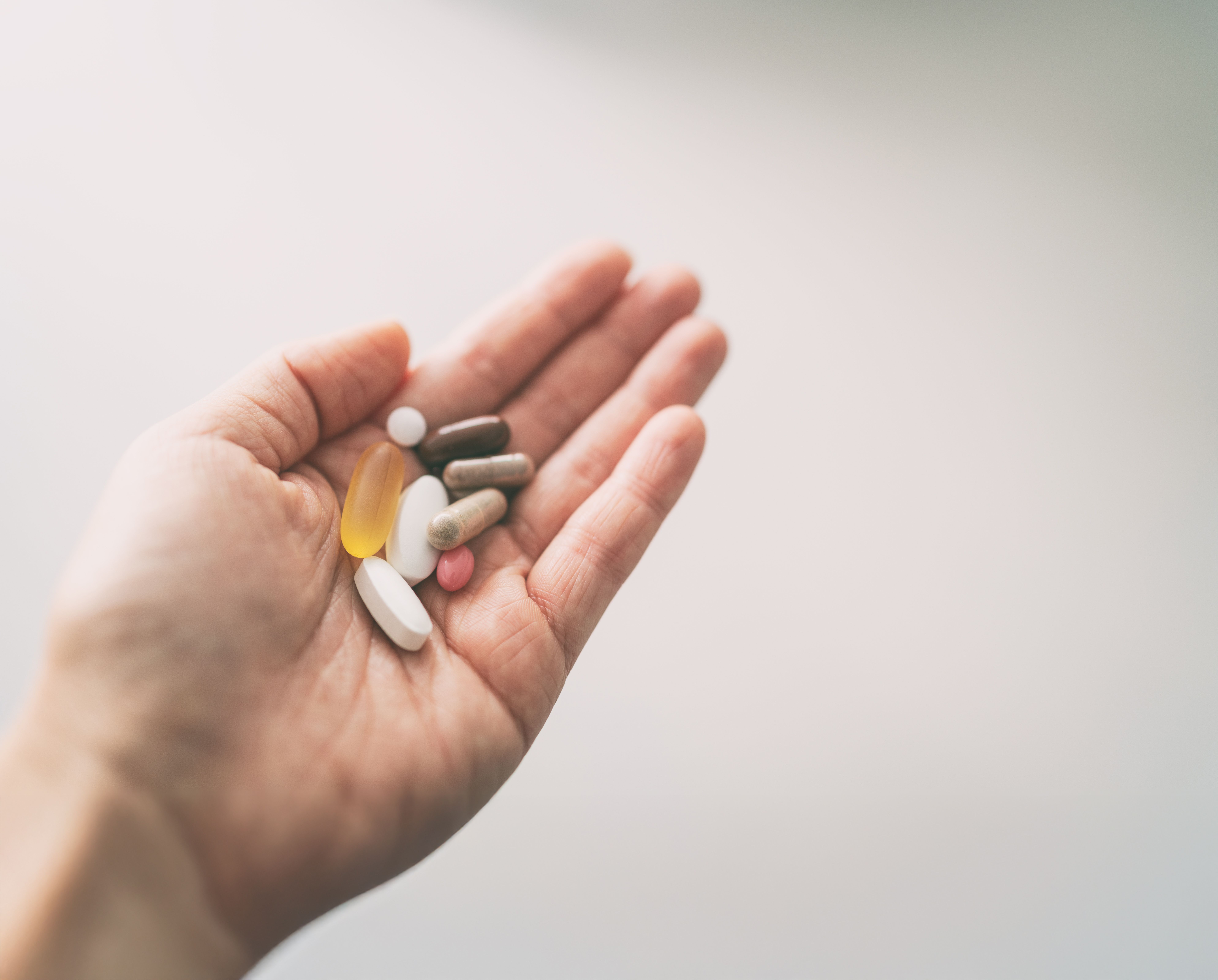 Hand holding an assortment of prescription pills