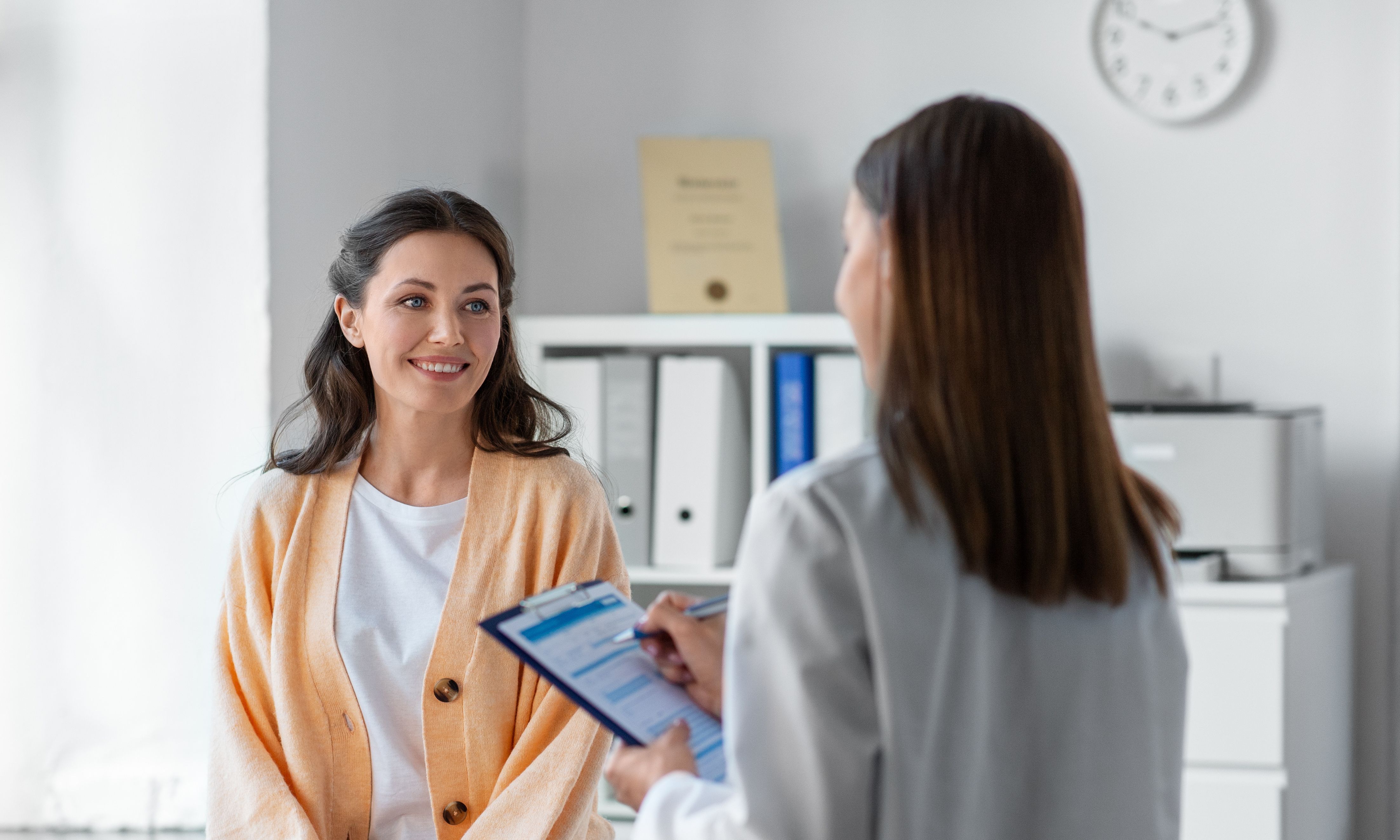 Woman talking to doctor in exam room
