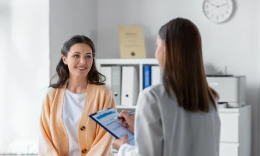 Woman talking to doctor in exam room