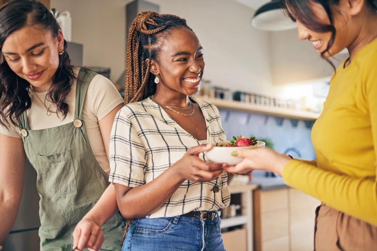 Woman in her 20s sharing meal with friends.