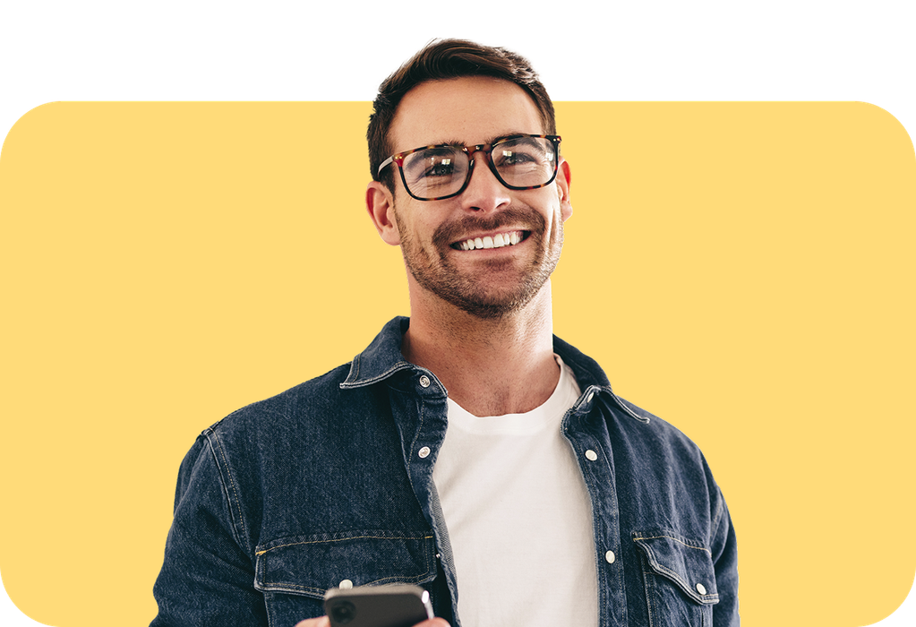 smiling man in denim shirt with iPhone
