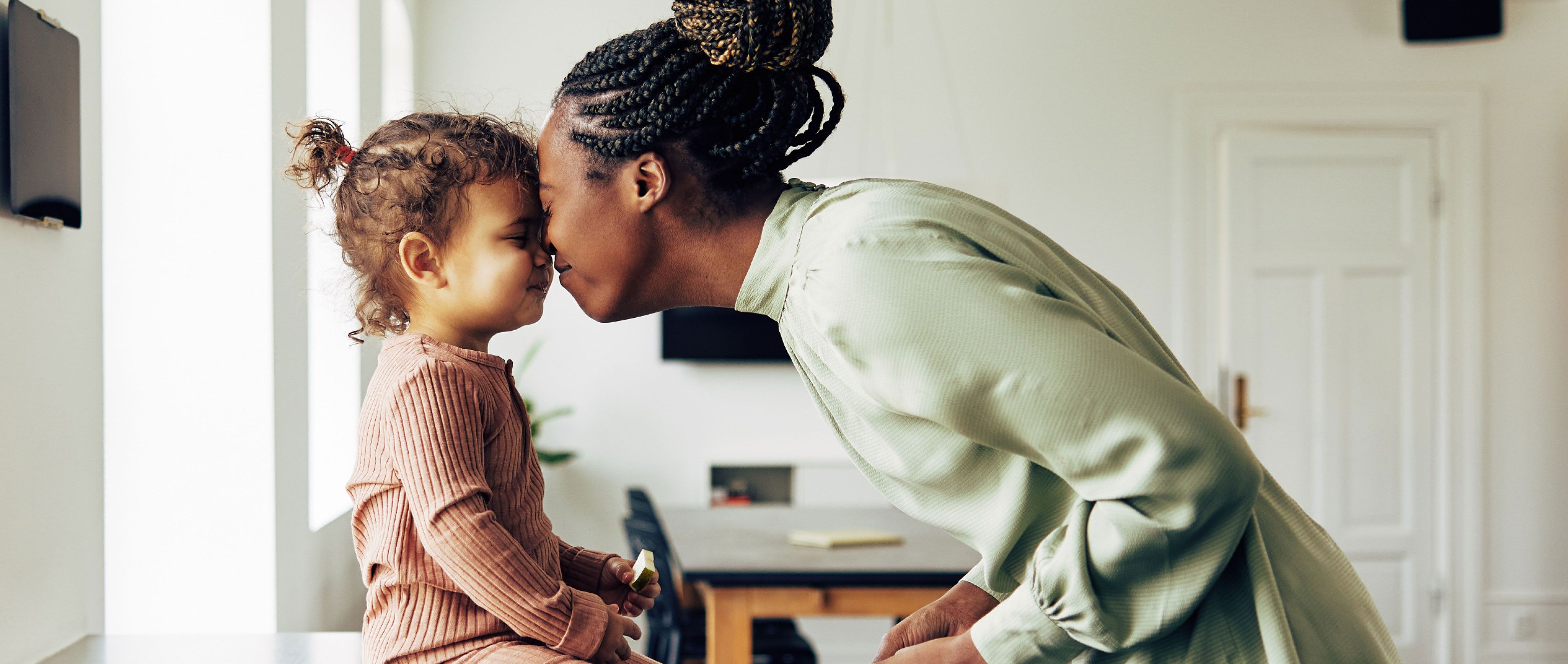 Woman and child touching foreheads and smiling