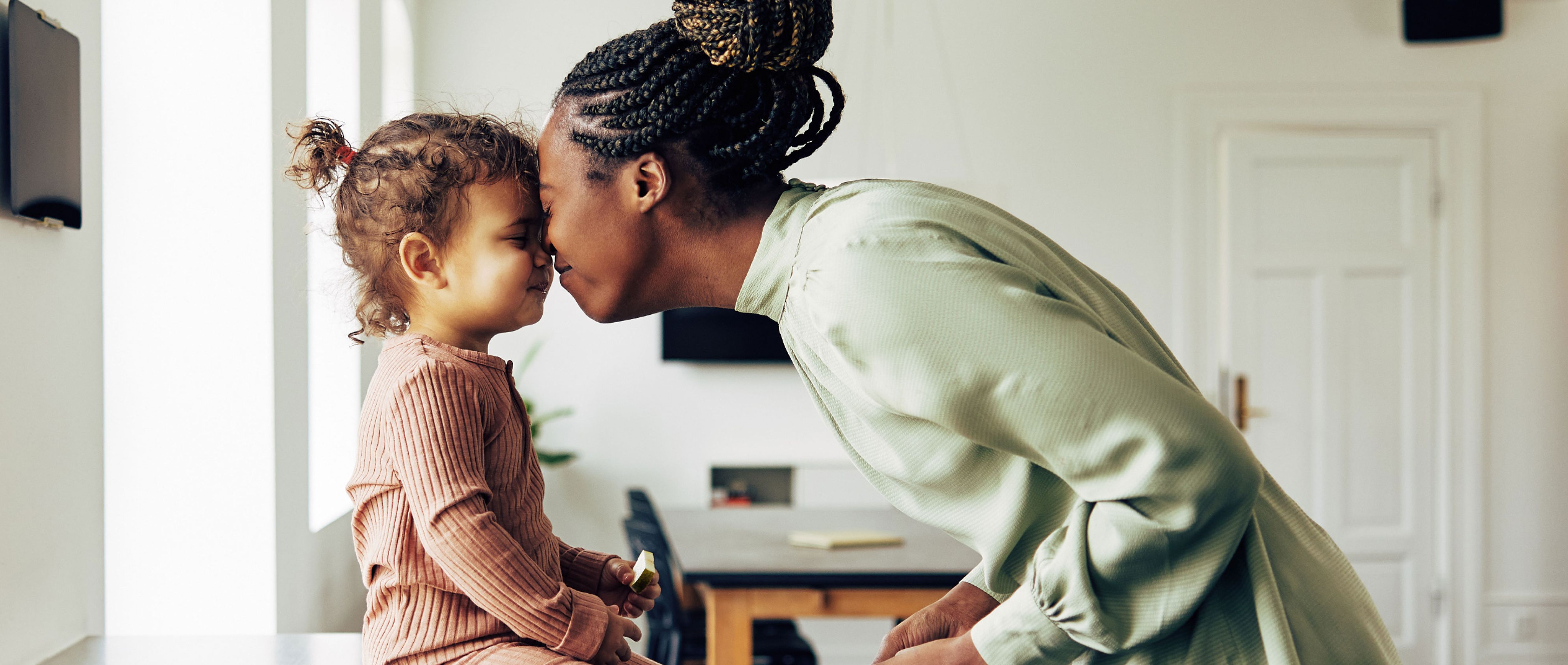 Woman and child touching foreheads and smiling