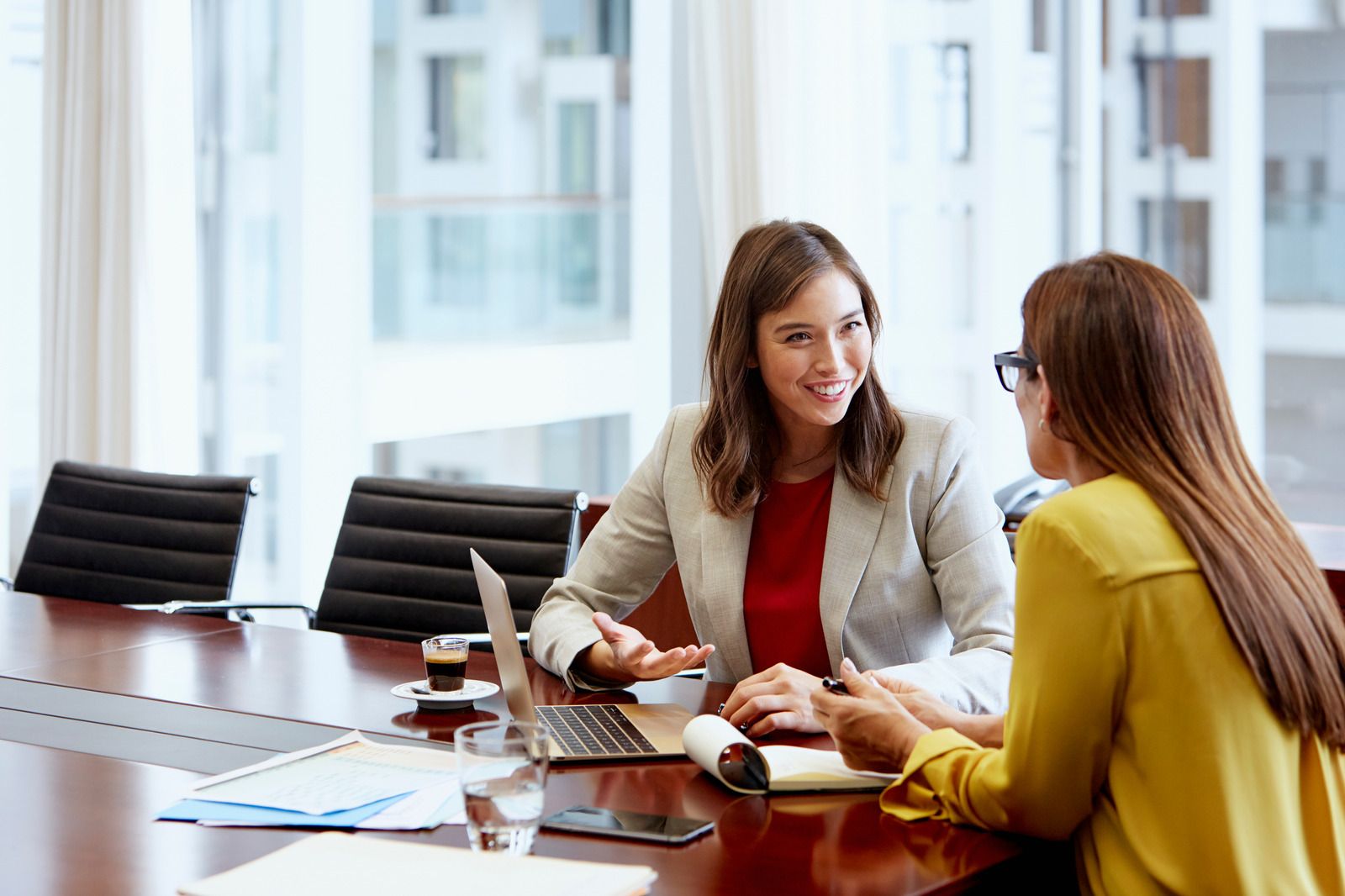 Two female coworkers having a conversation in the office