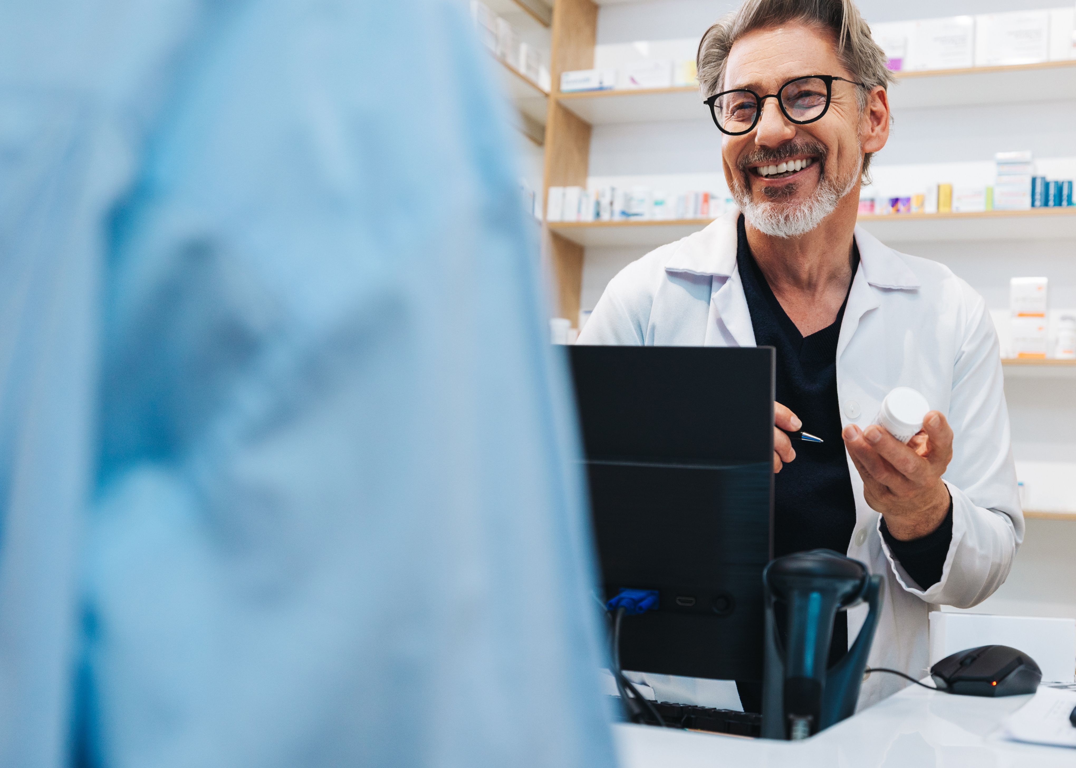 smiling pharmacist talking to customer 