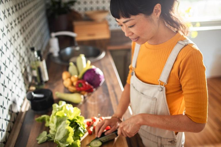 Woman chopping fresh vegetables.
