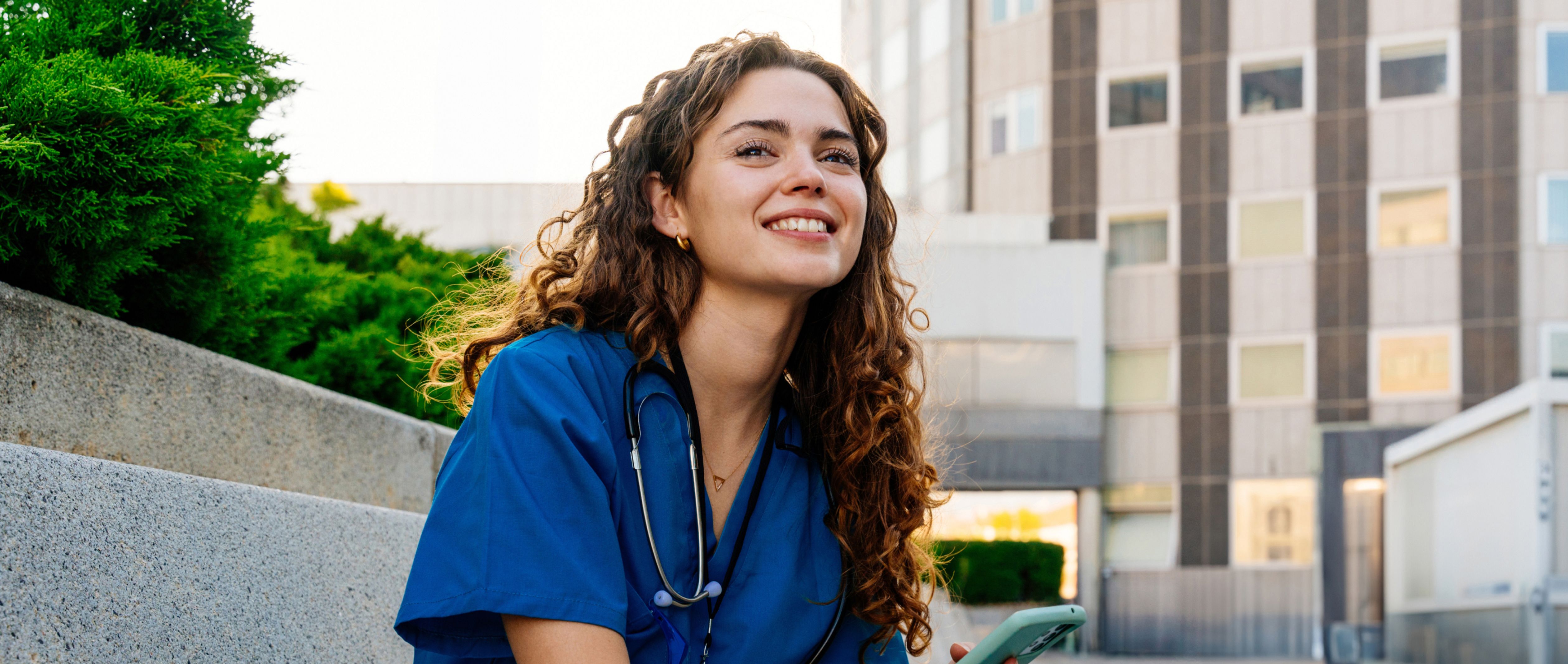 Smiling healthcare professional sitting outside.