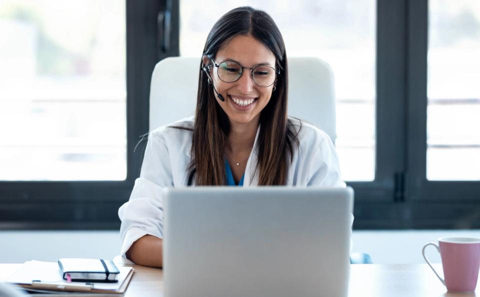female healthcare working smiling at computer
