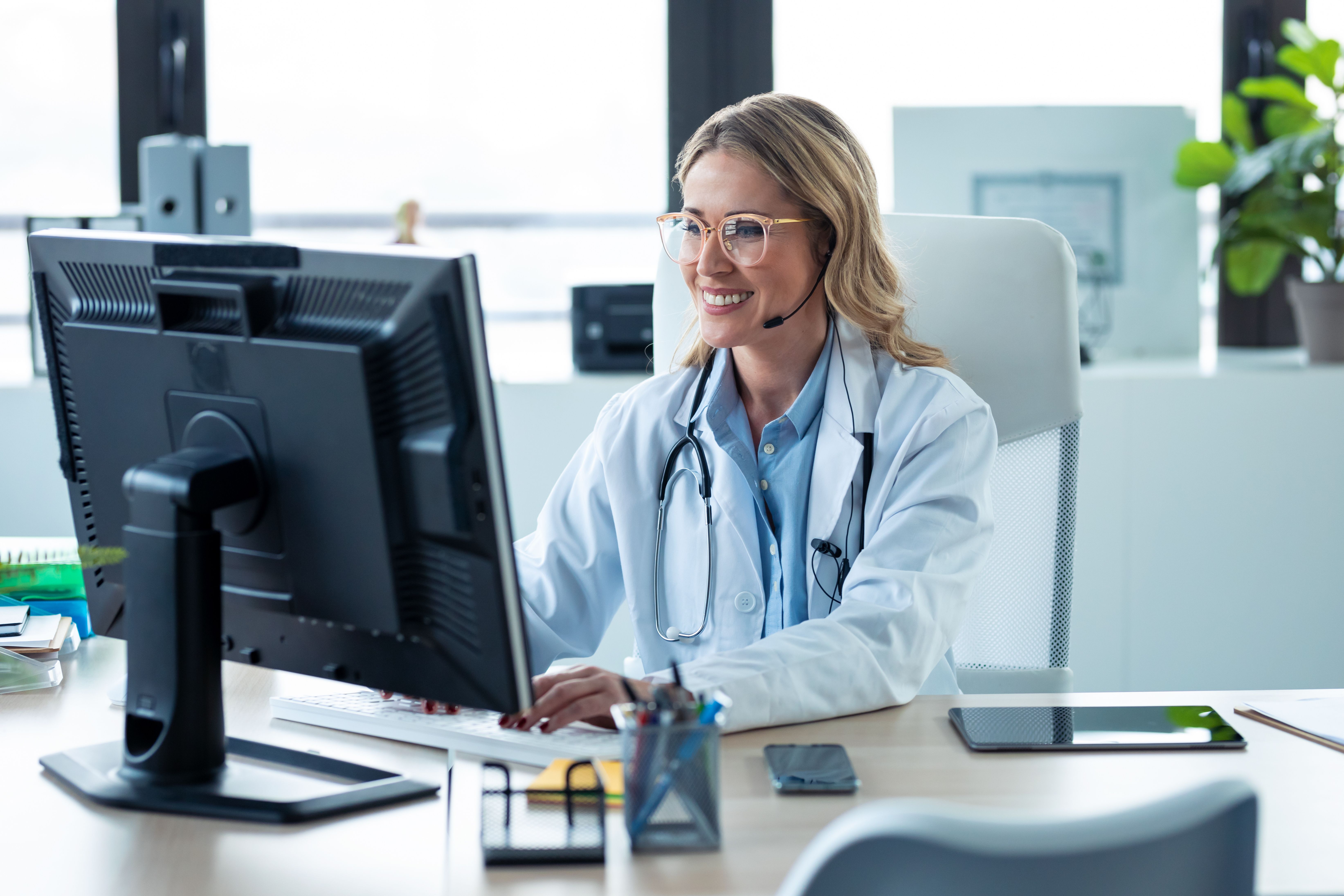 Female doctor sitting at computer smiling