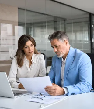 Man and woman coworkers sitting and looking at papers