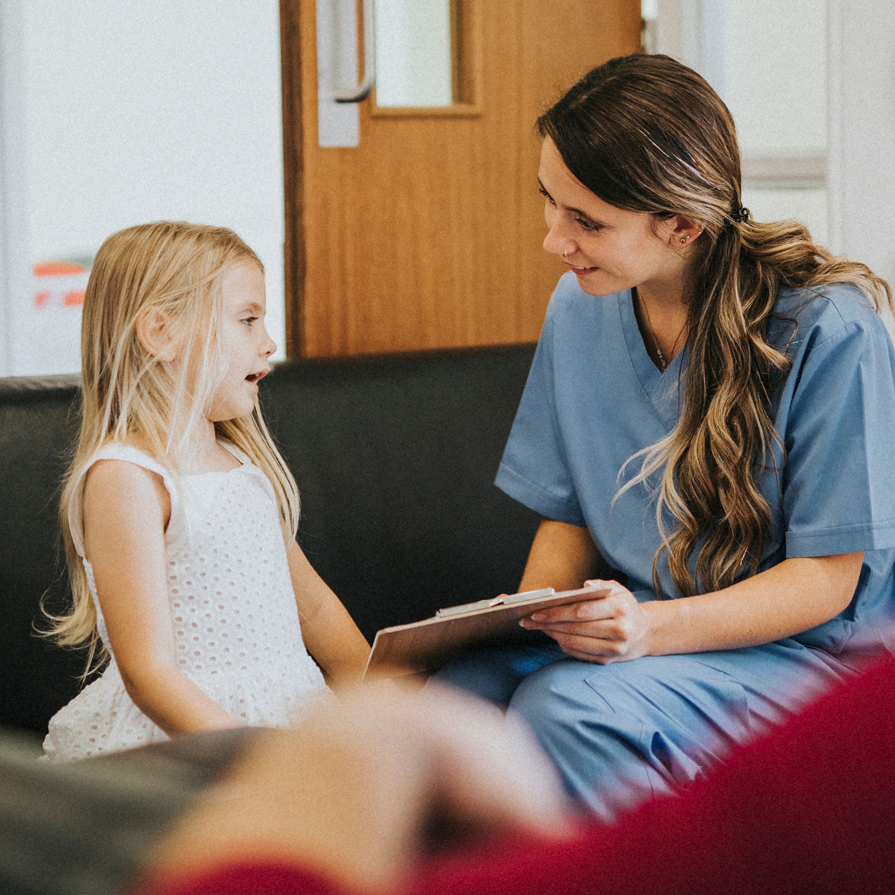 Woman nurse speaking with a child in a doctors office