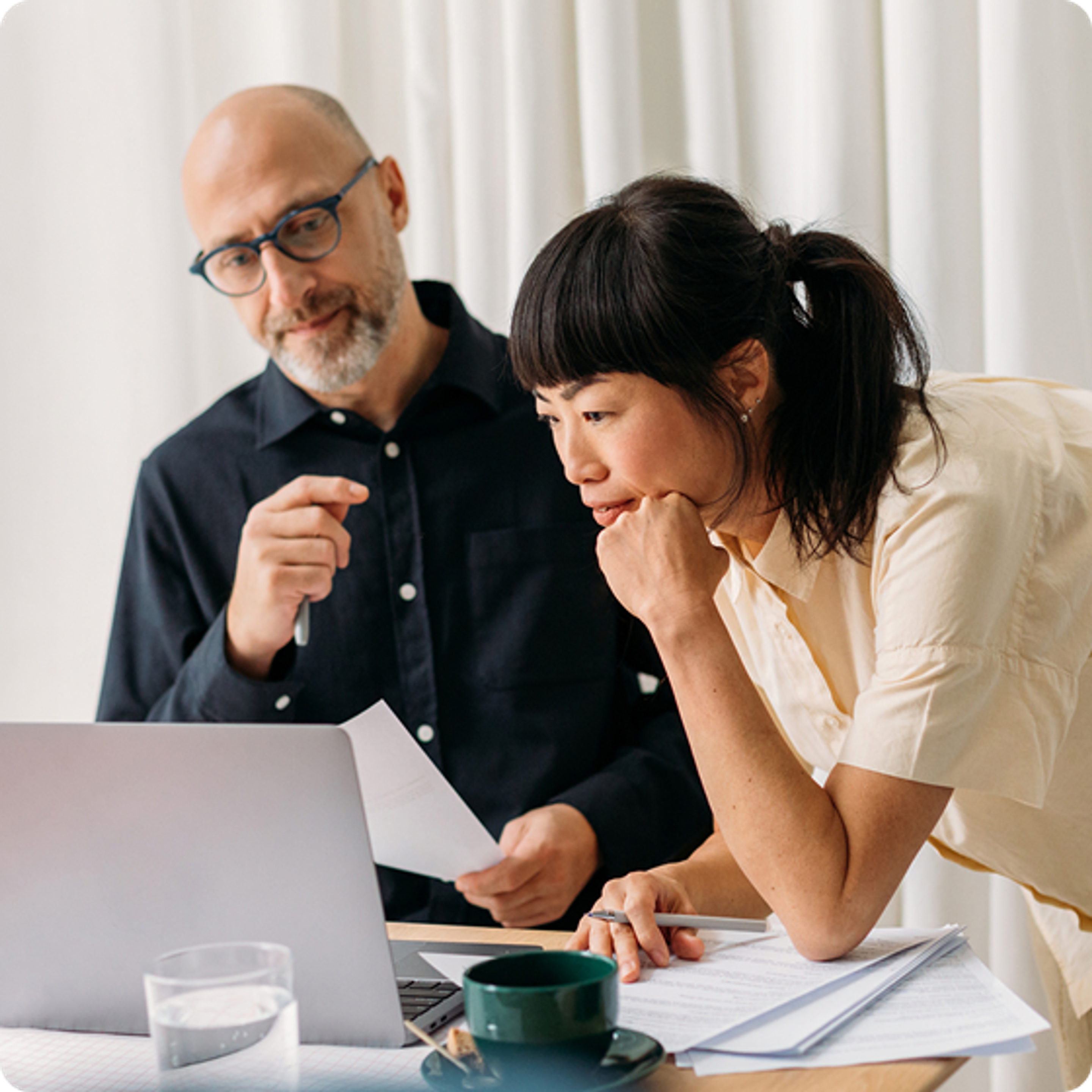 Two coworkers looking at laptop