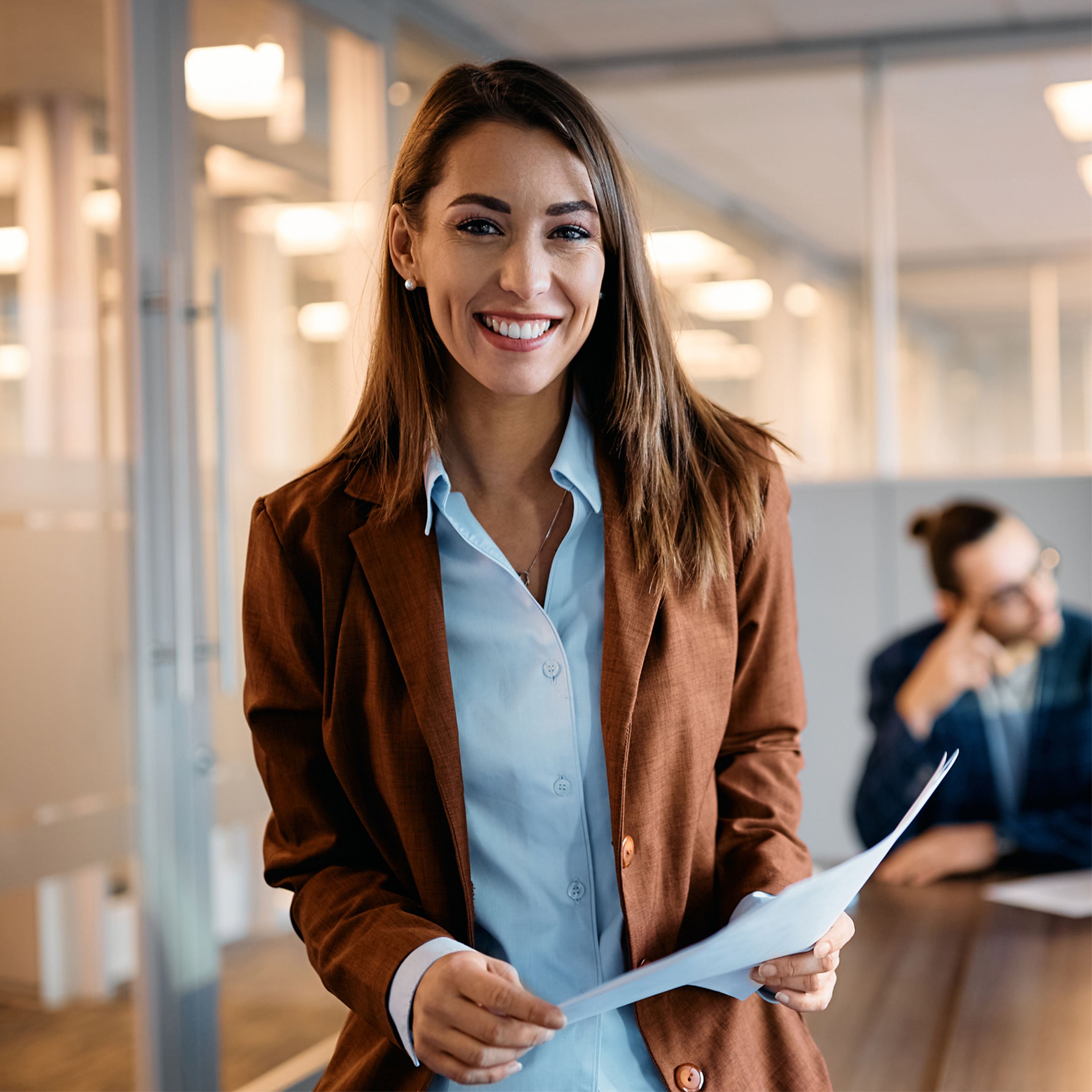 Woman in office holding paper and smiling