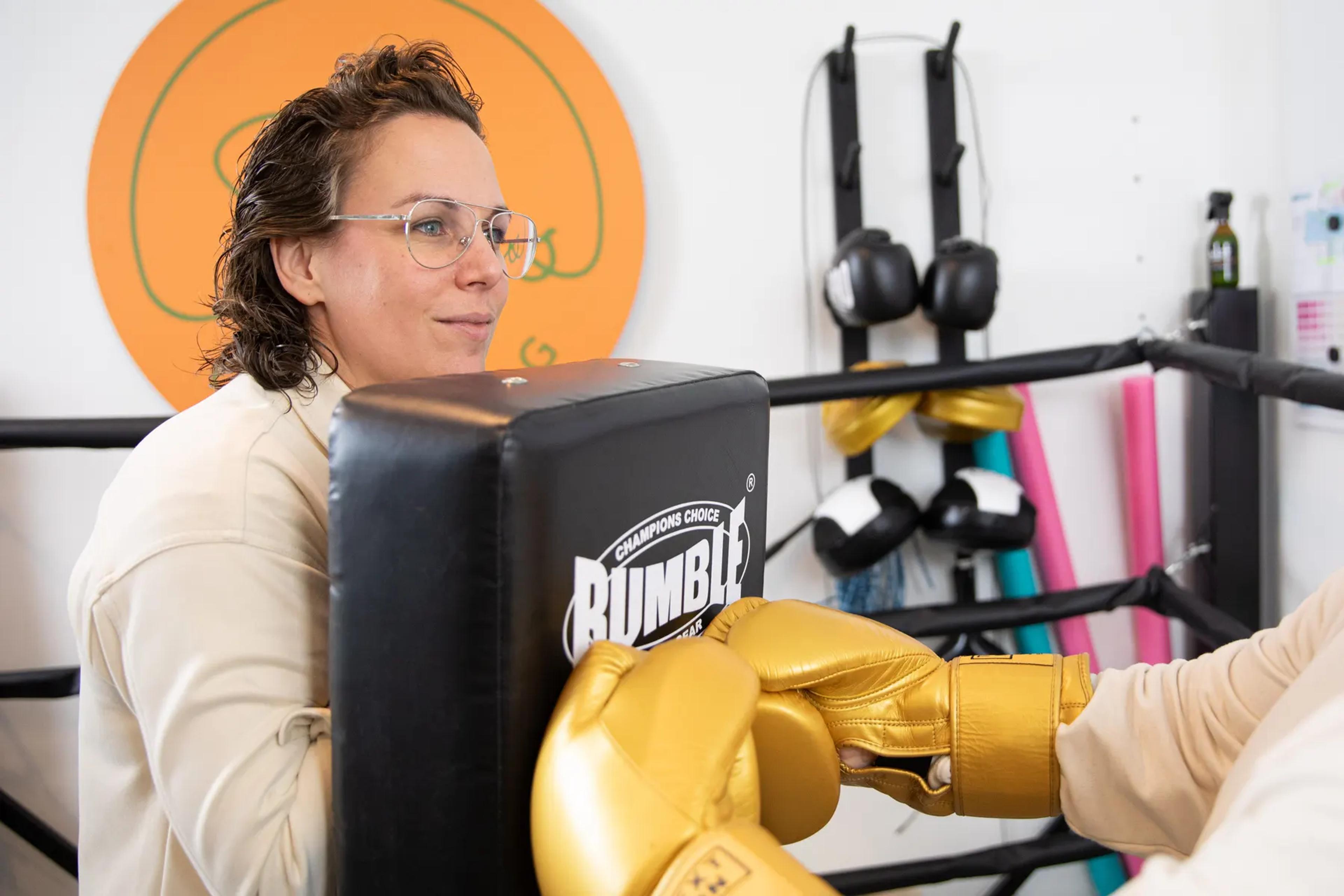 Een cliënt stoot op het stootkussen dat Samantha vasthoudt