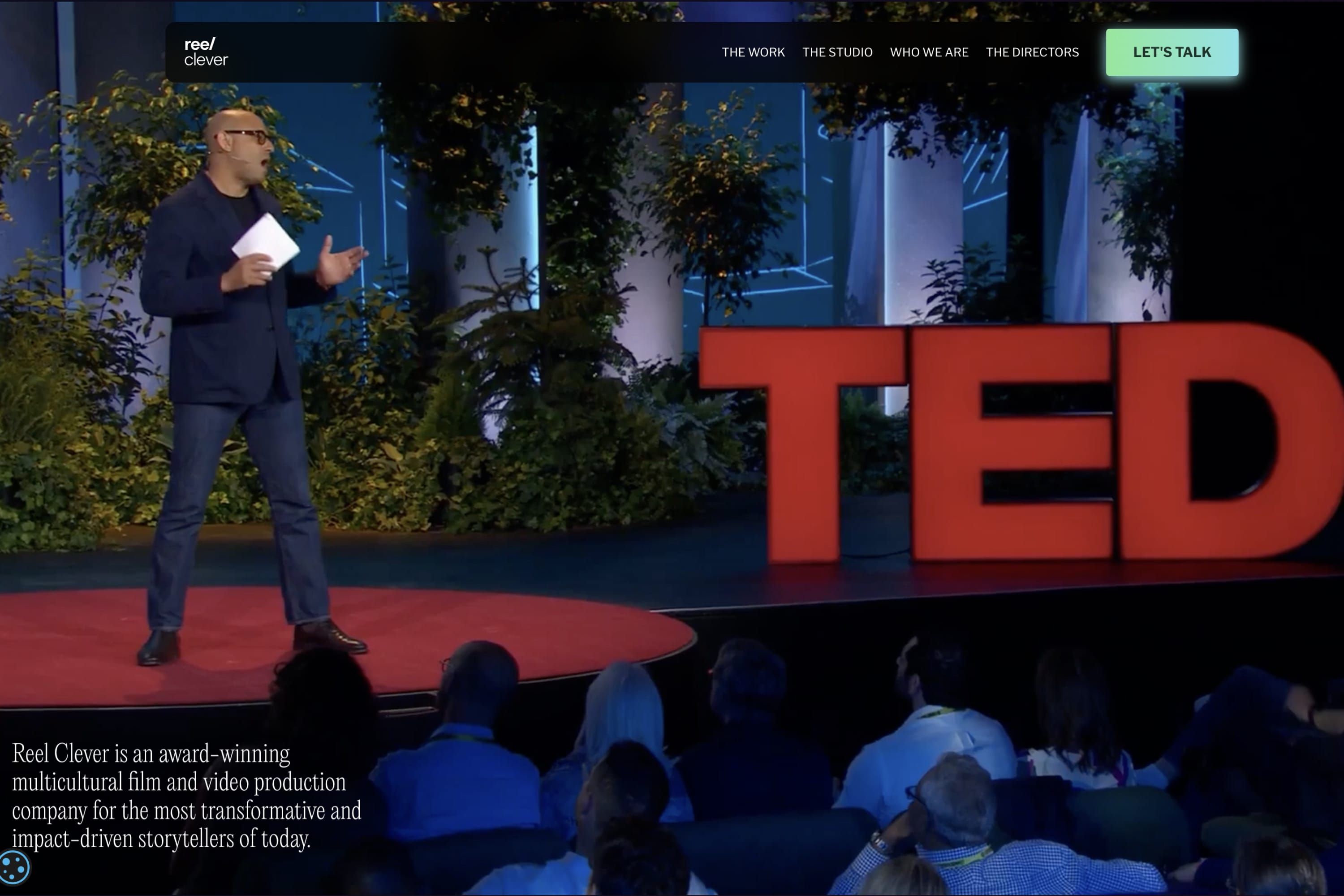 Reel Clever's redesigned home page: a speaker on the TED stage in a full-width video, with the navigation and a Let's Talk button above and the studio's description below.