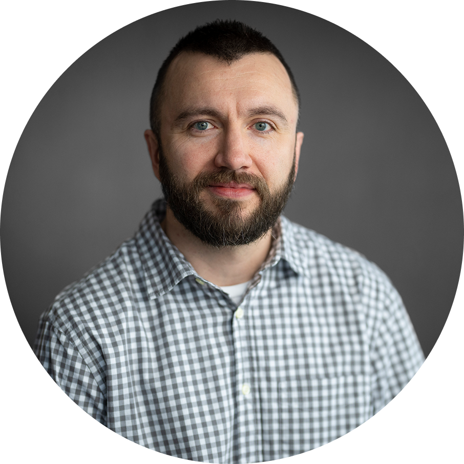 Man with beard and blue eyes in a gray and white checkered shirt. Portrait.