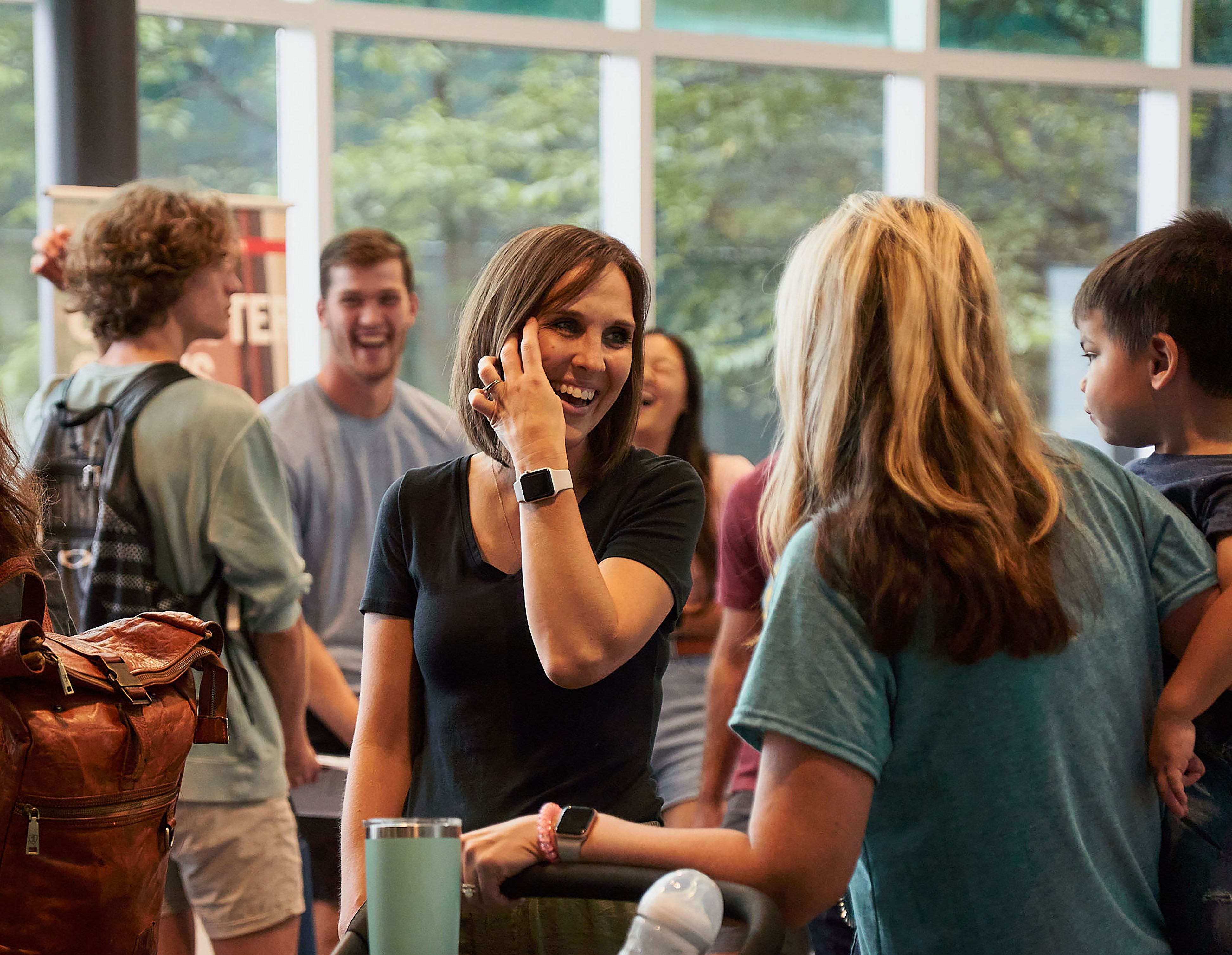 Hope Church members smiling and laughing together in the lobby after Sunday morning worship.