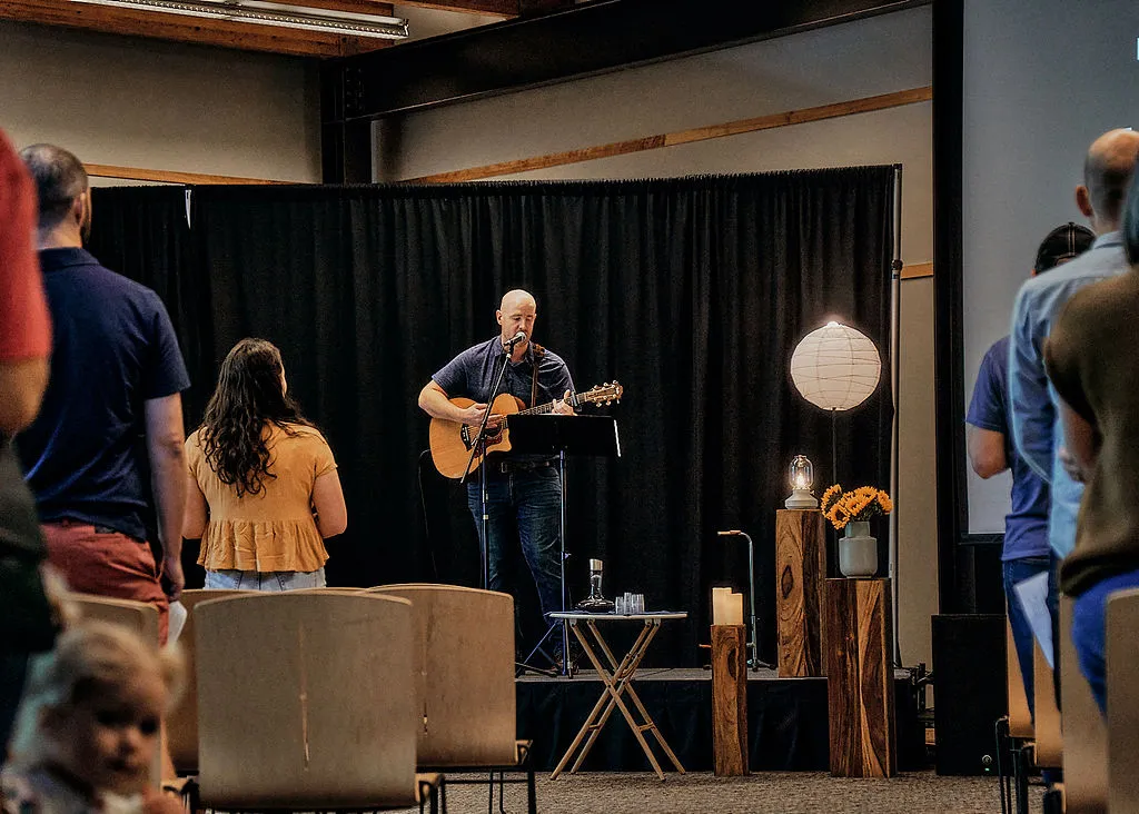 The Hope worship team leading Sunday morning worship with acoustic guitar and congregational singing.