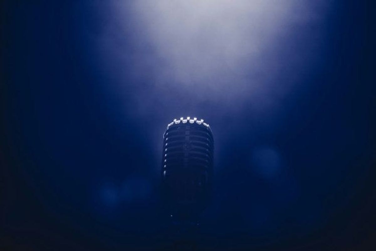 Vintage microphone under spotlight in dim lighting. event marketing strategy, event marketing, event planning, engage attendees