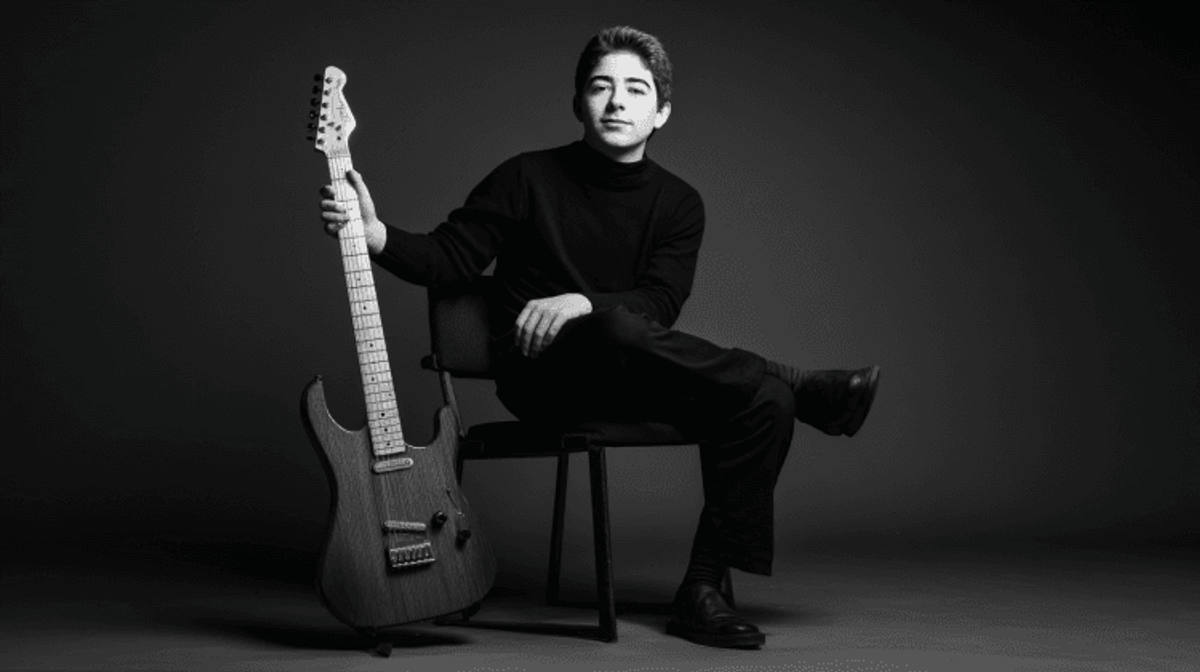 Person with electric guitar in black and white photo.