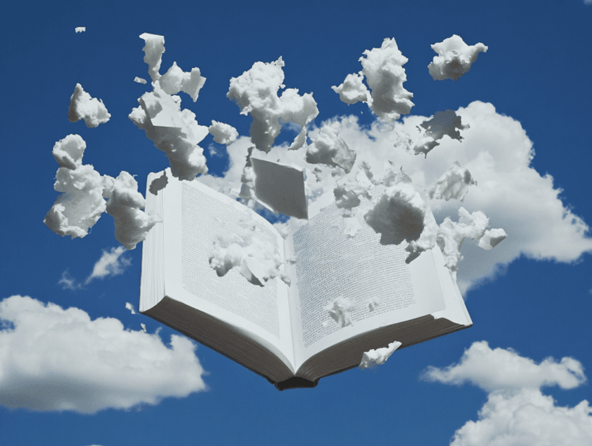 Open book dissolving into floating clouds