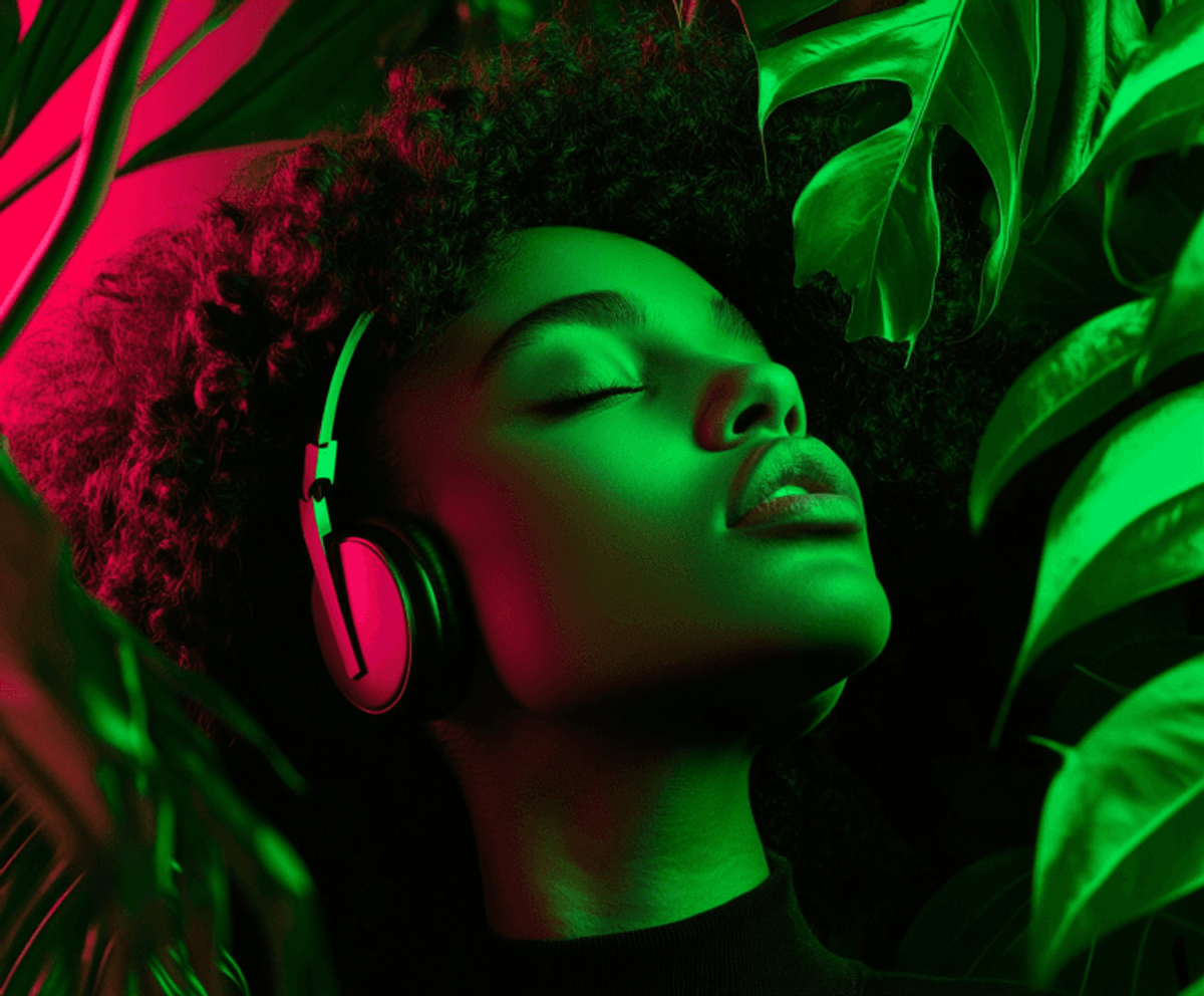 Person enjoying music with headphones in colorful lighting.