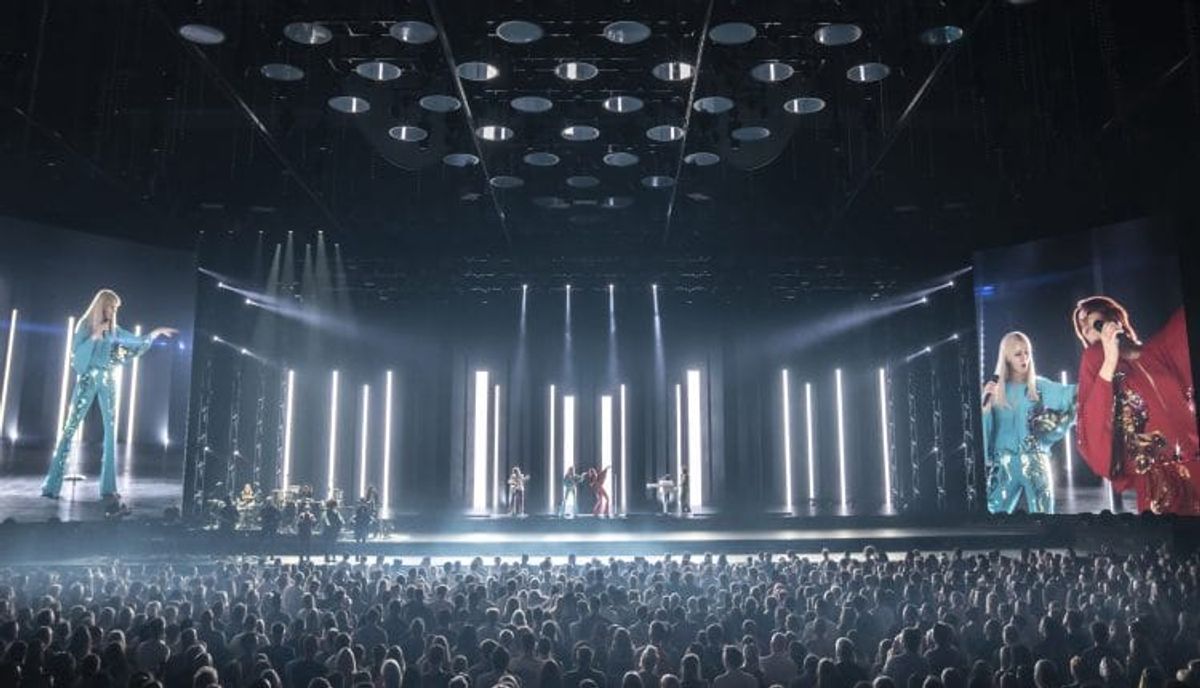 Concert with large audience and performers on stage.