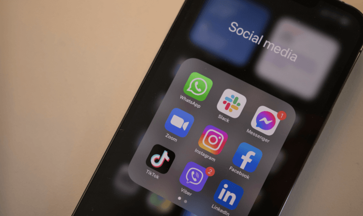 Smartphone with social media app icons on screen.