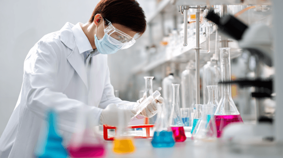 Scientist conducting experiment with colorful lab equipment.