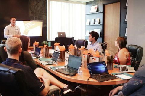 Marketing team collaborating around a conference table with laptops