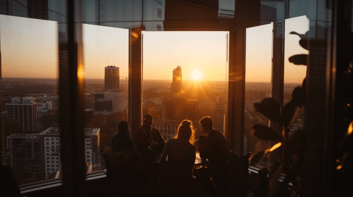 People in skyscraper admire sunset cityscape view