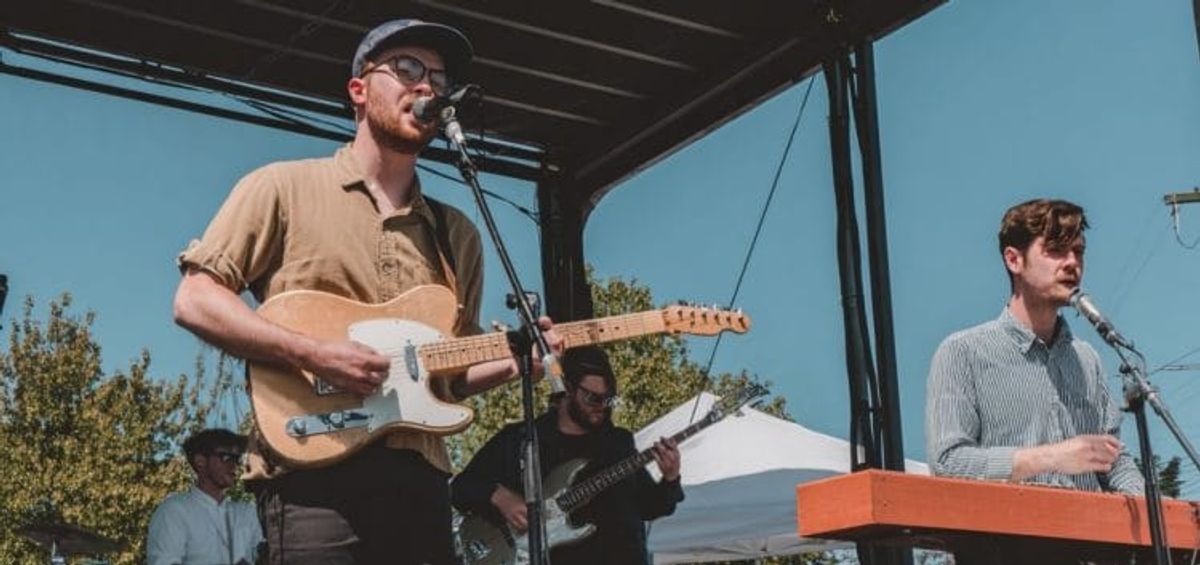 Band performing outdoors on a sunny day.