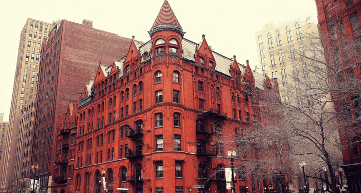 Historic red-brick building in snowy urban setting.