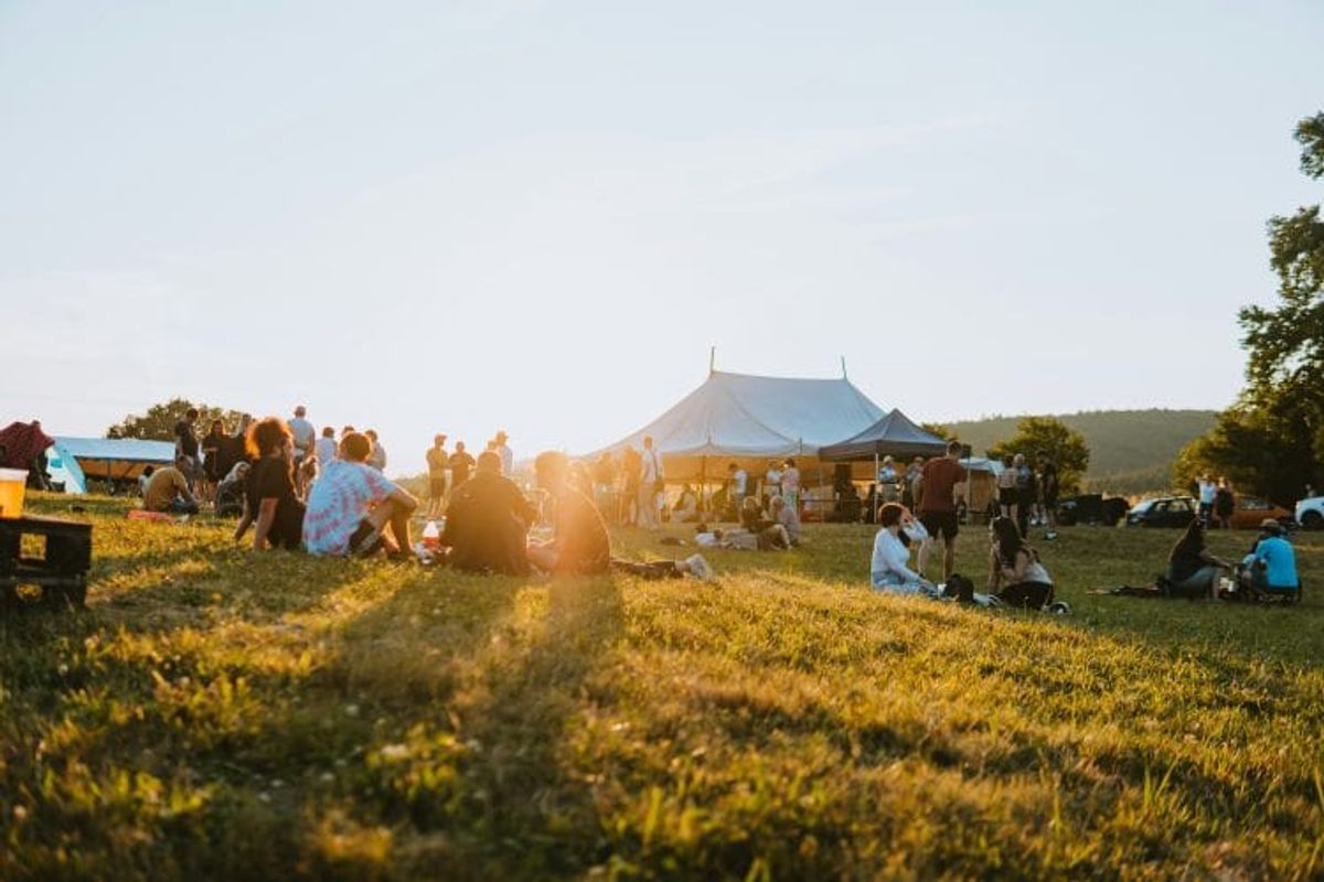 Outdoor festival with people relaxing on grass