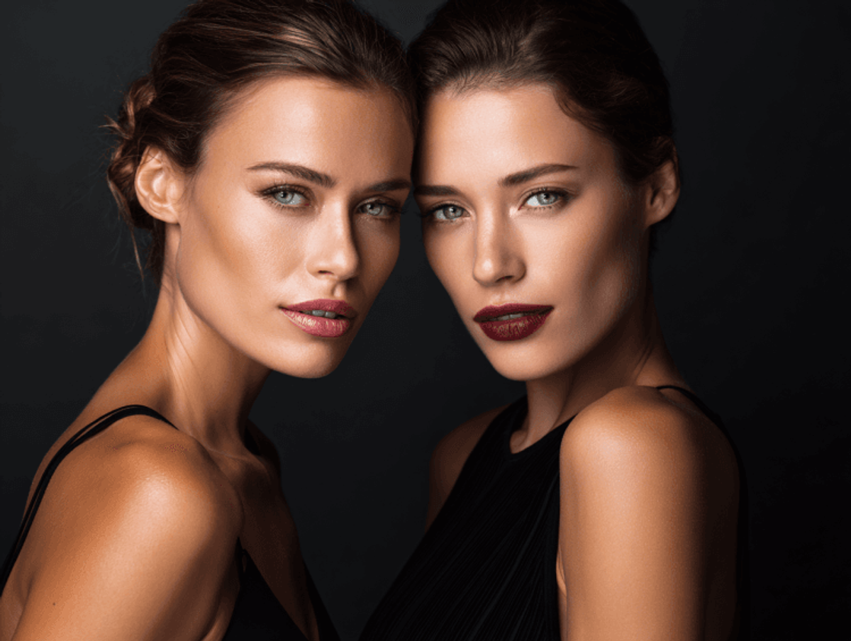 Two women posing in elegant black outfits