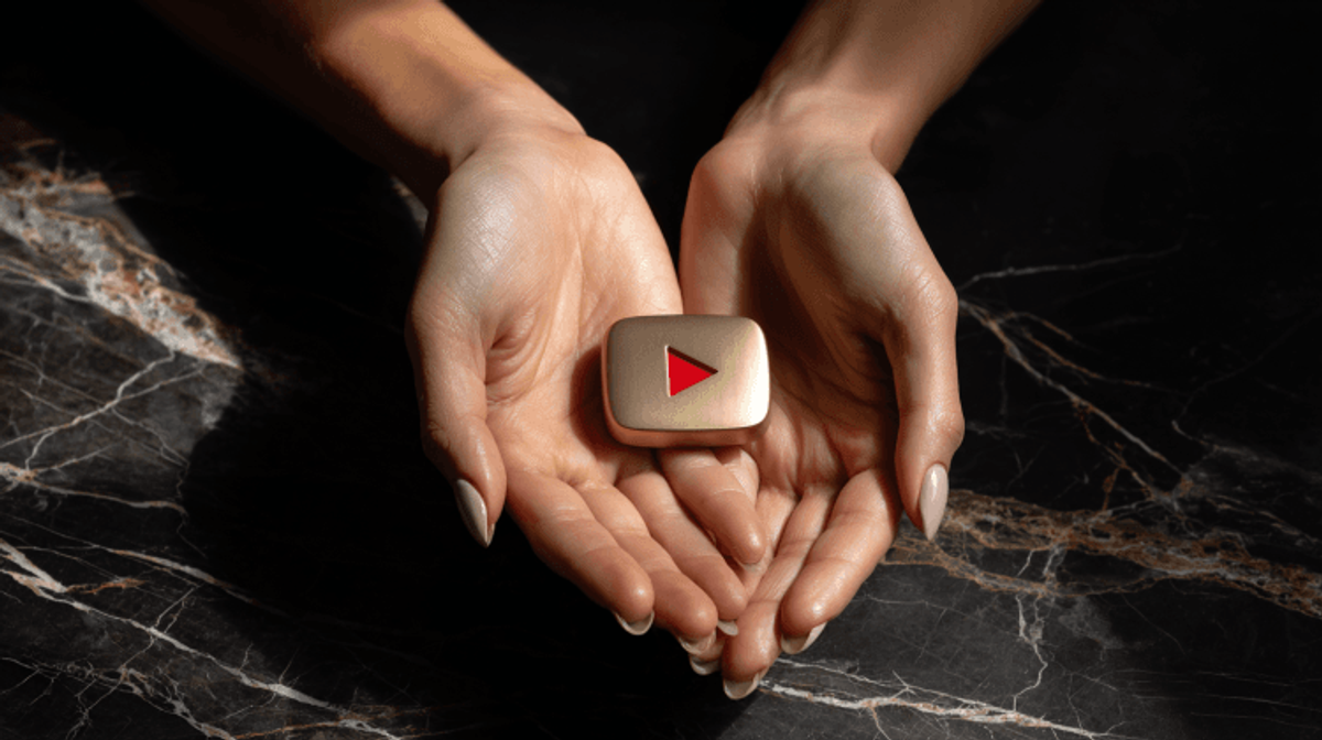 Hands holding gold YouTube Play Button