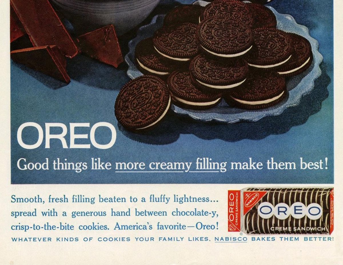 Lower part of a 1961 color magazine advertisement: a plate of Oreo cookies beside pieces of chocolate on a blue background, with the headline Oreo, Good things like more creamy filling make them best, and a Nabisco Oreo Creme Sandwich package