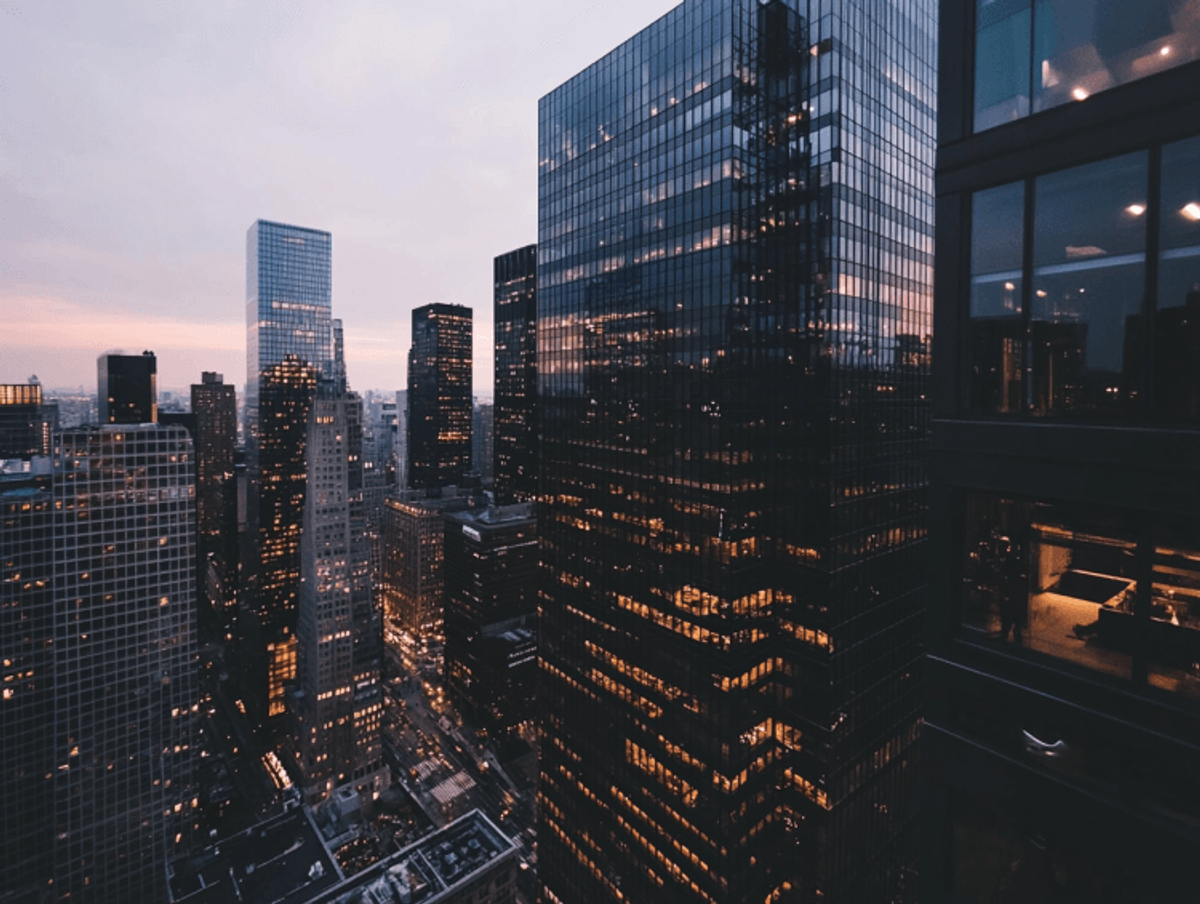 City skyline at dusk with illuminated skyscrapers.