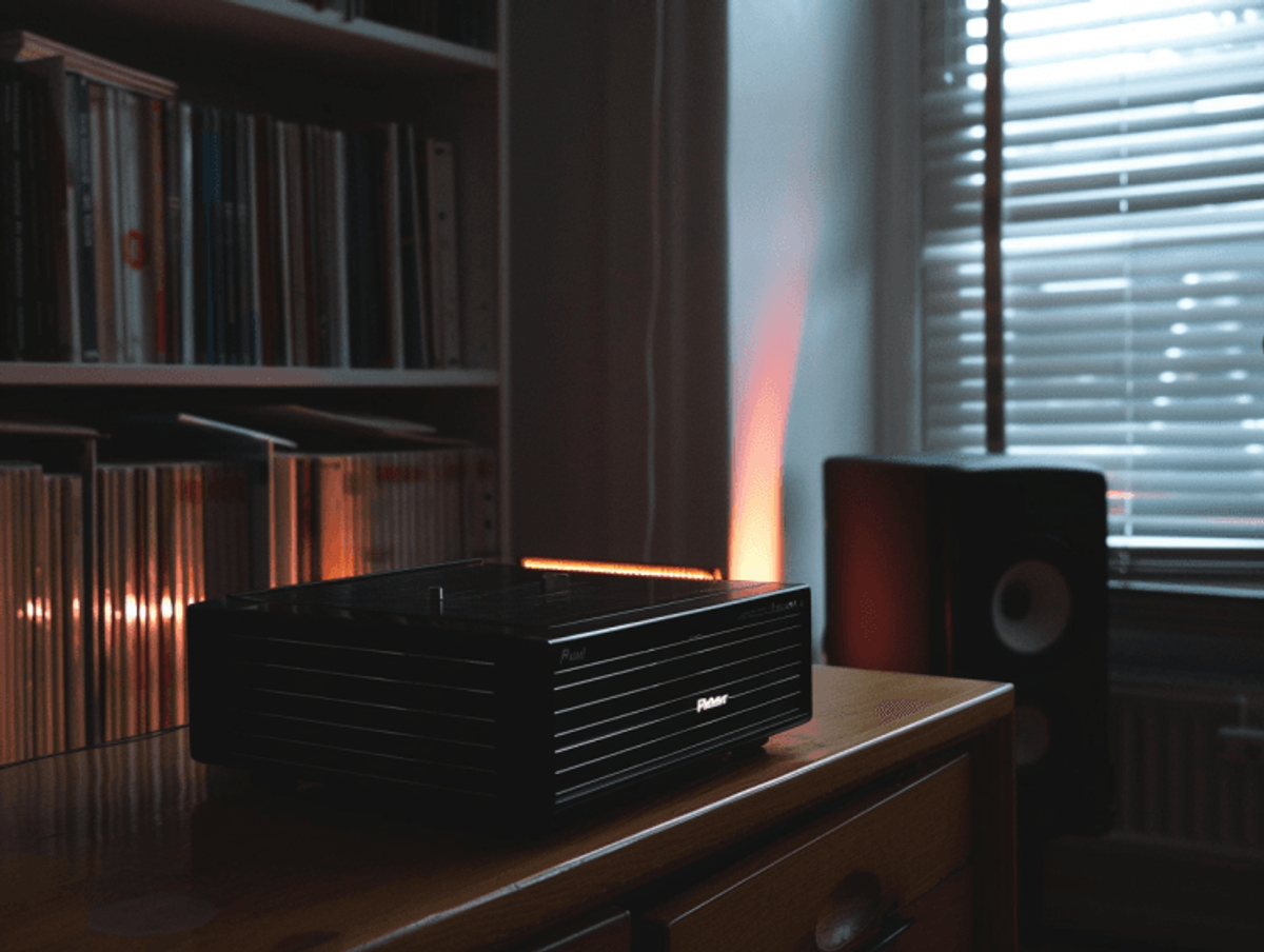 Modern stereo receiver on wooden cabinet.
