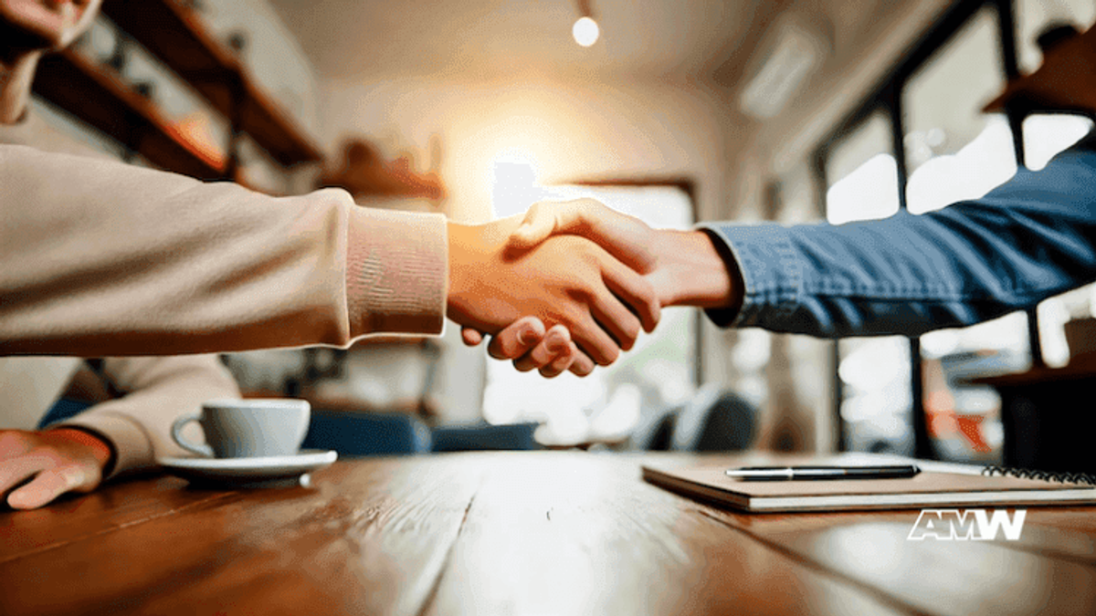 Business handshake at a cafe table.