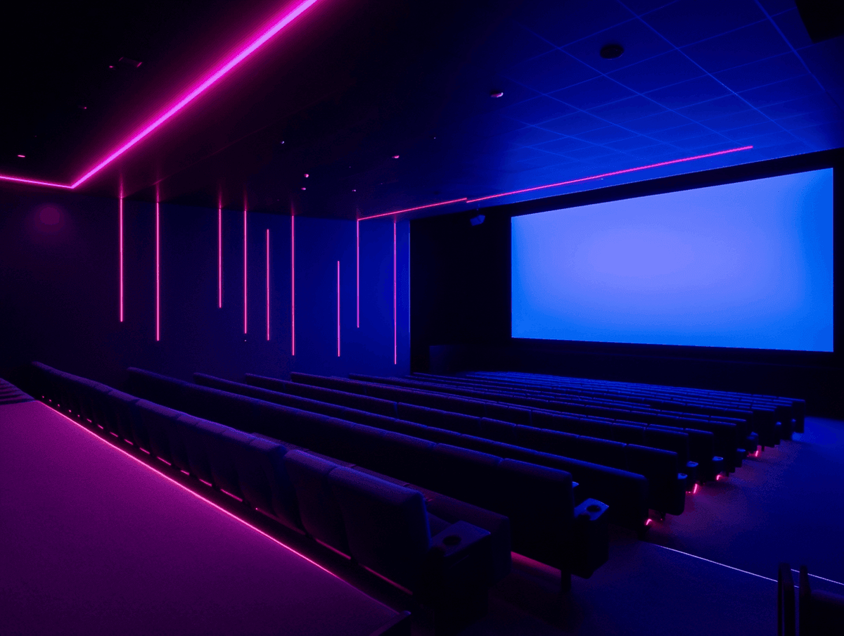 Empty theater with neon lighting and screen.