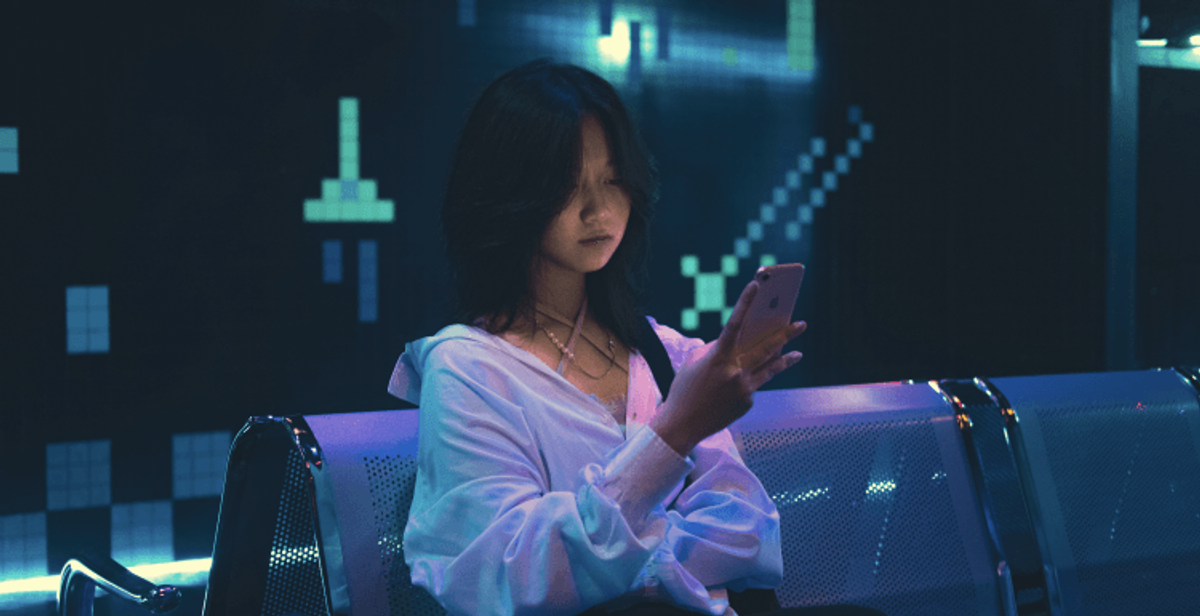 Person browsing smartphone in a tech-inspired setting