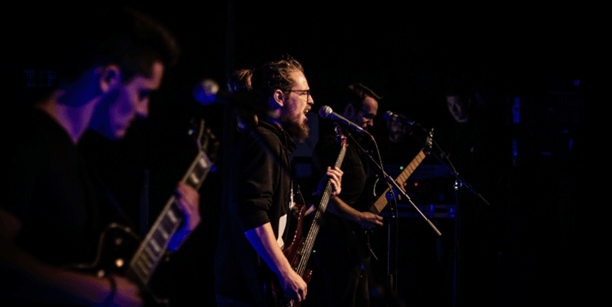 Band performing live on stage with guitars