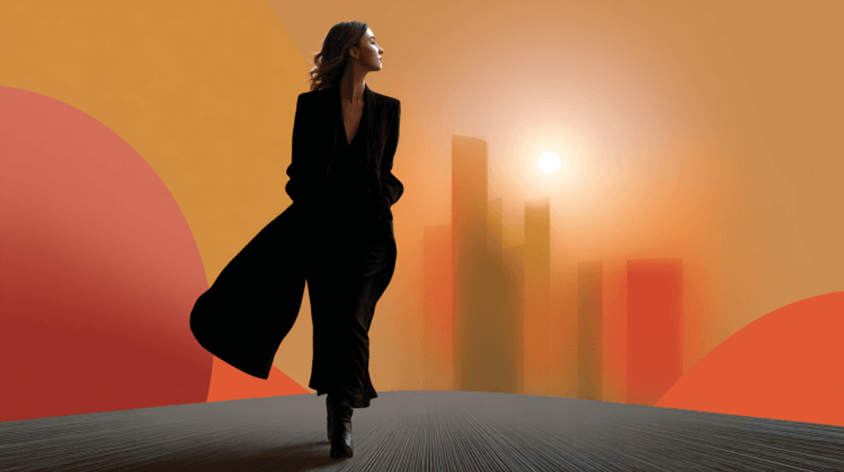 Fashionable woman walking at sunset with cityscape.