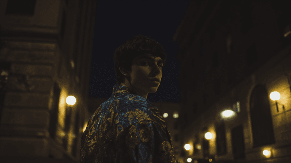 Person in colorful jacket on dimly lit street.