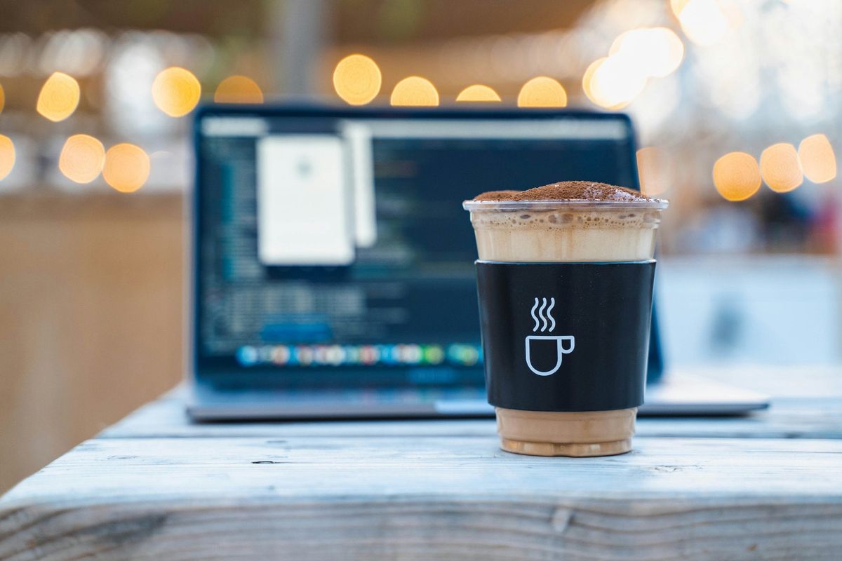 Iced coffee in front of a laptop
