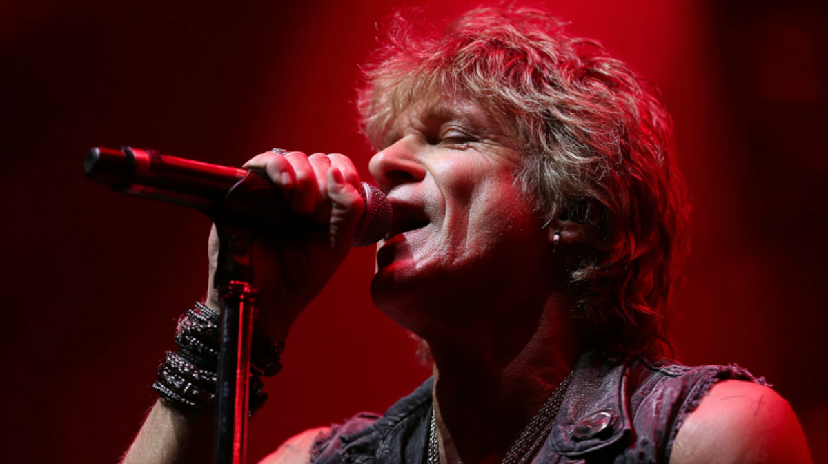 Singer performing passionately onstage with microphone.