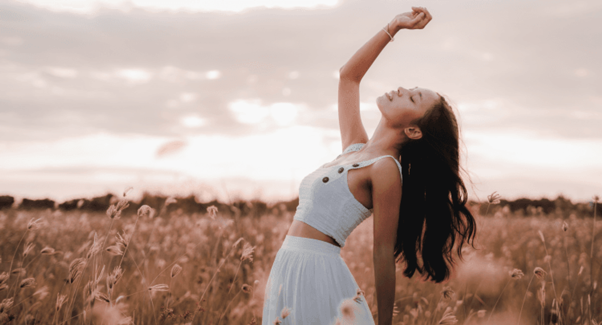 Woman enjoying sunset in a wheat field