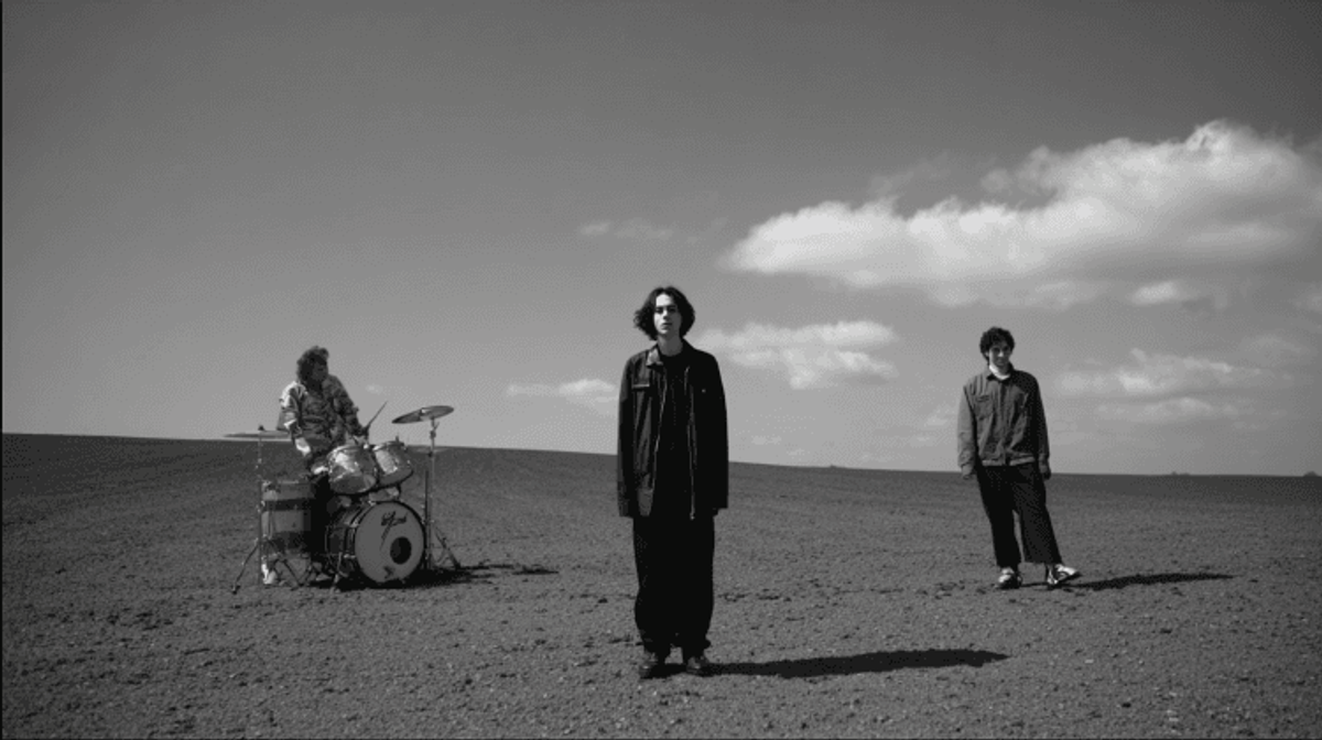 Musicians on barren landscape, black and white photo.